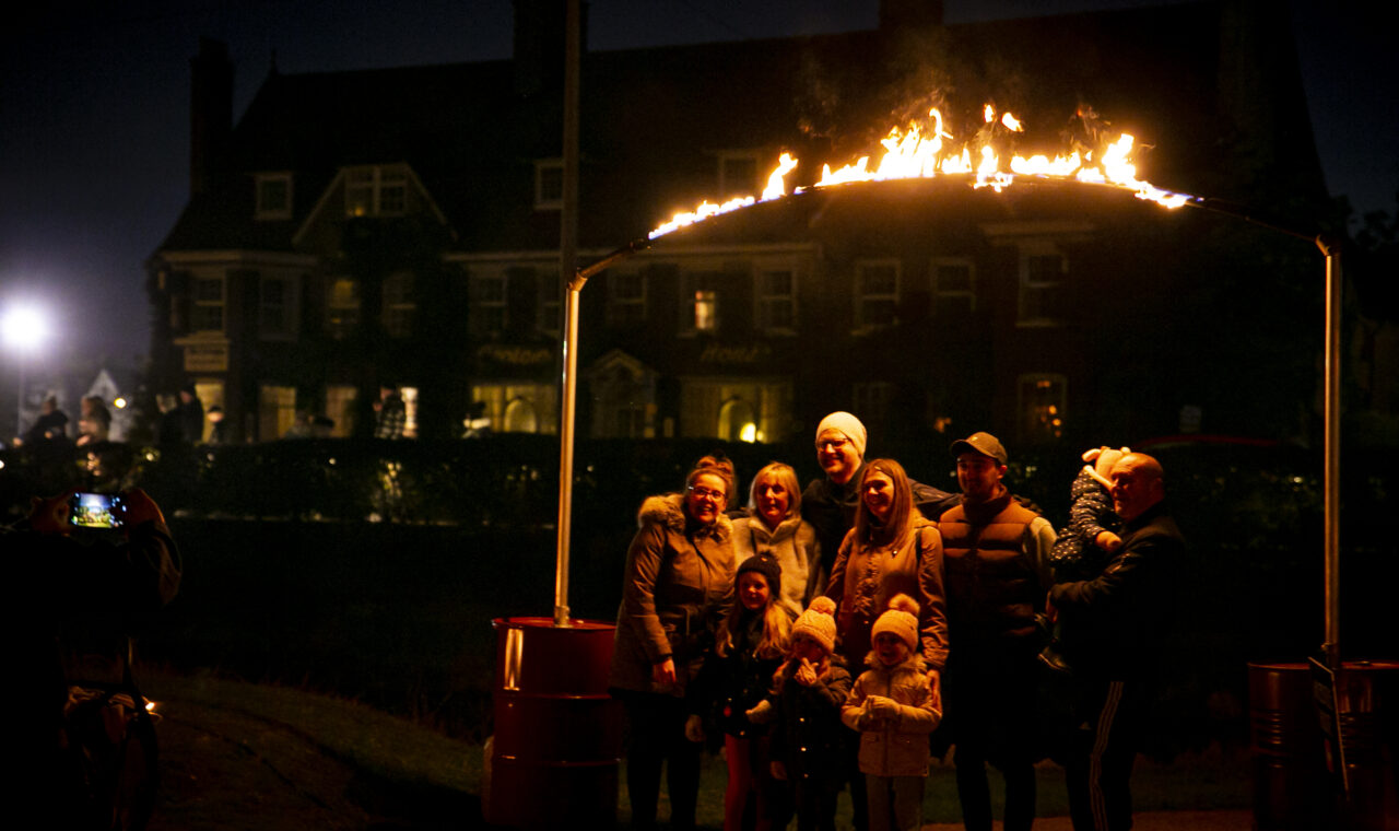 Family stands under a fire arch