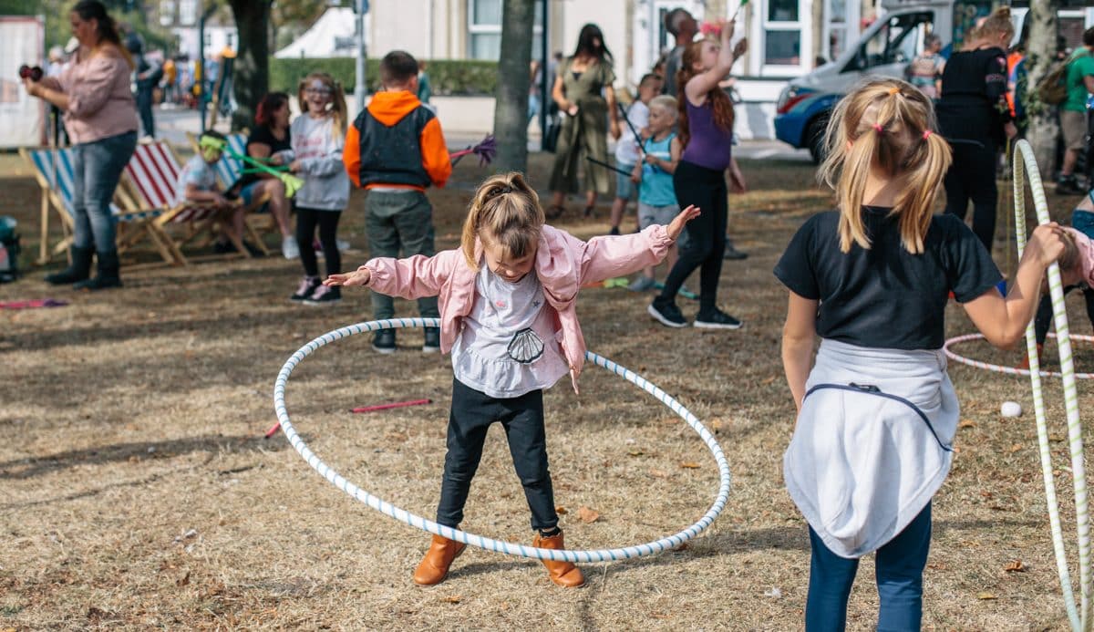 Girl practices hula hoop in the park.