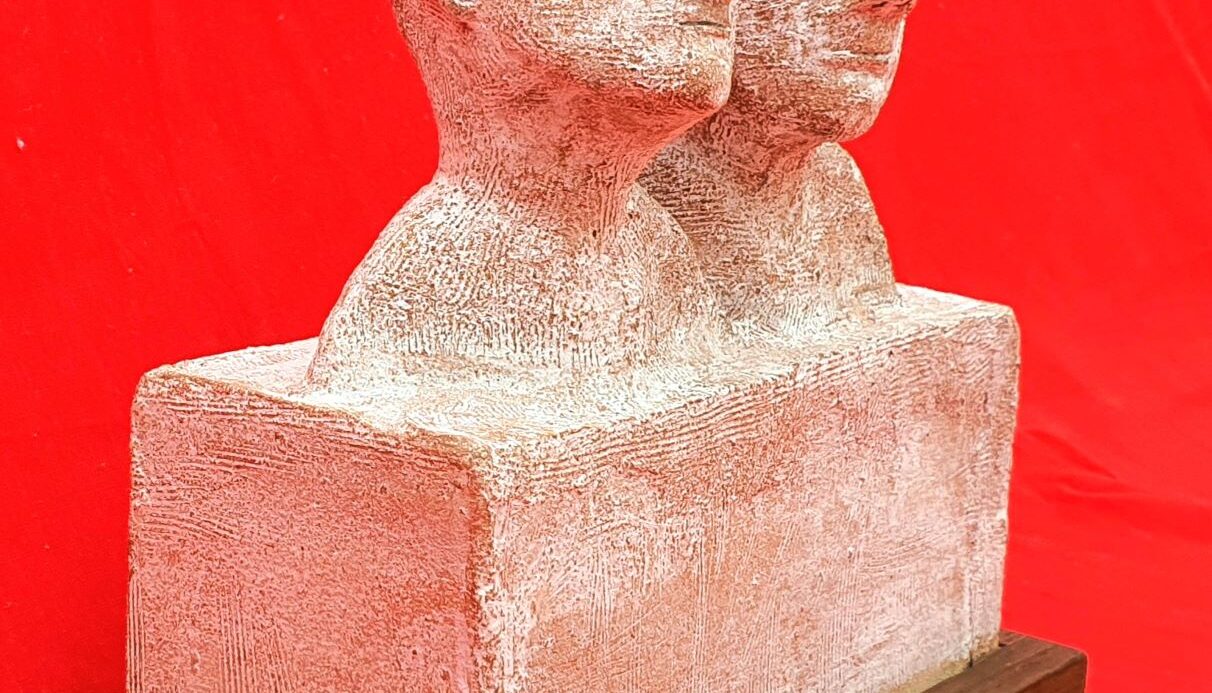 Picture of a sculpture depicting two human heads in a sleepy state