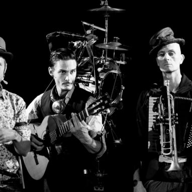 Black and white photo of three one man band performers together
