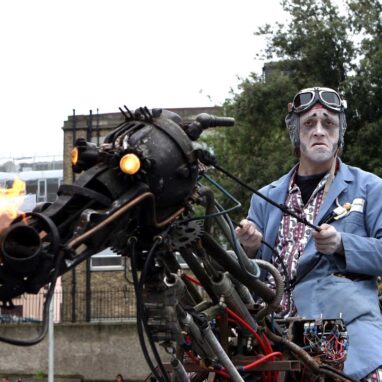 PAKA THE UNCREDIBLE sad man in funny suit riding a mechanical horse with glowing eyes and fire breath