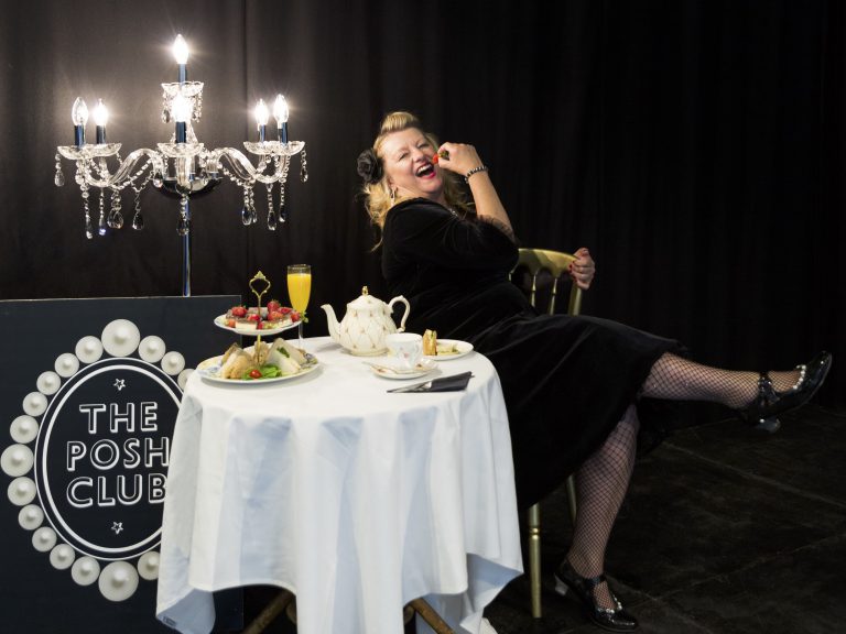 Posh Club host enjoying themselves at a table with afternoon tea