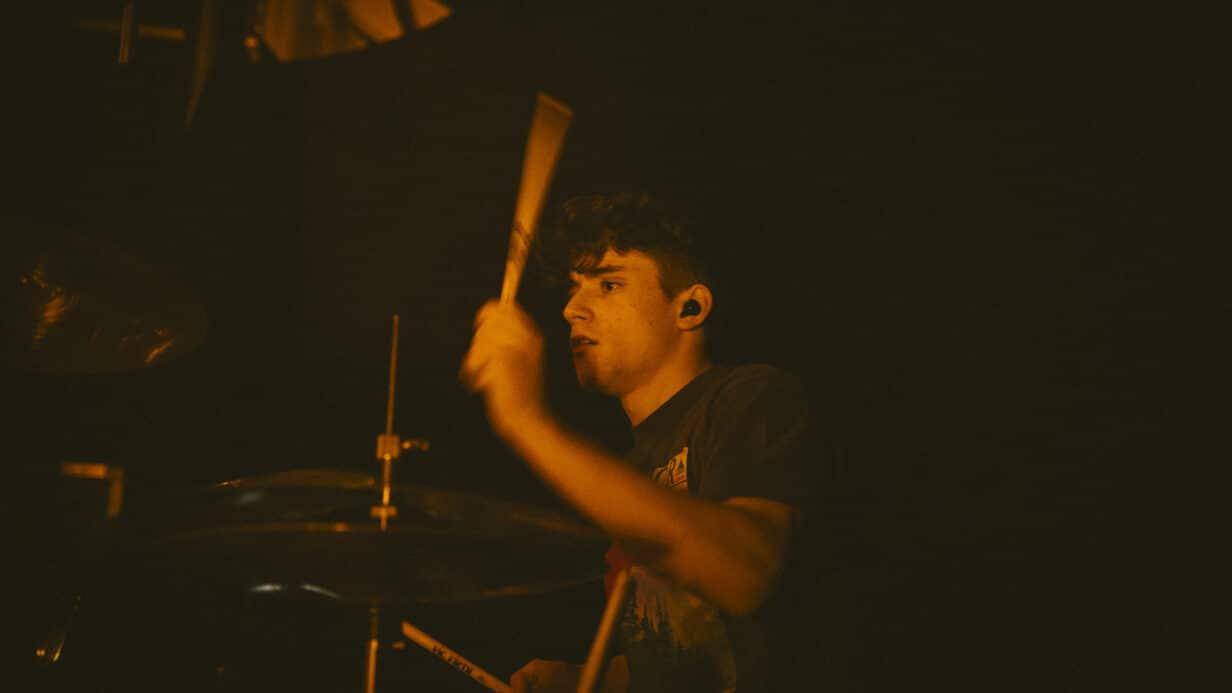 A drummer playing music in amber light