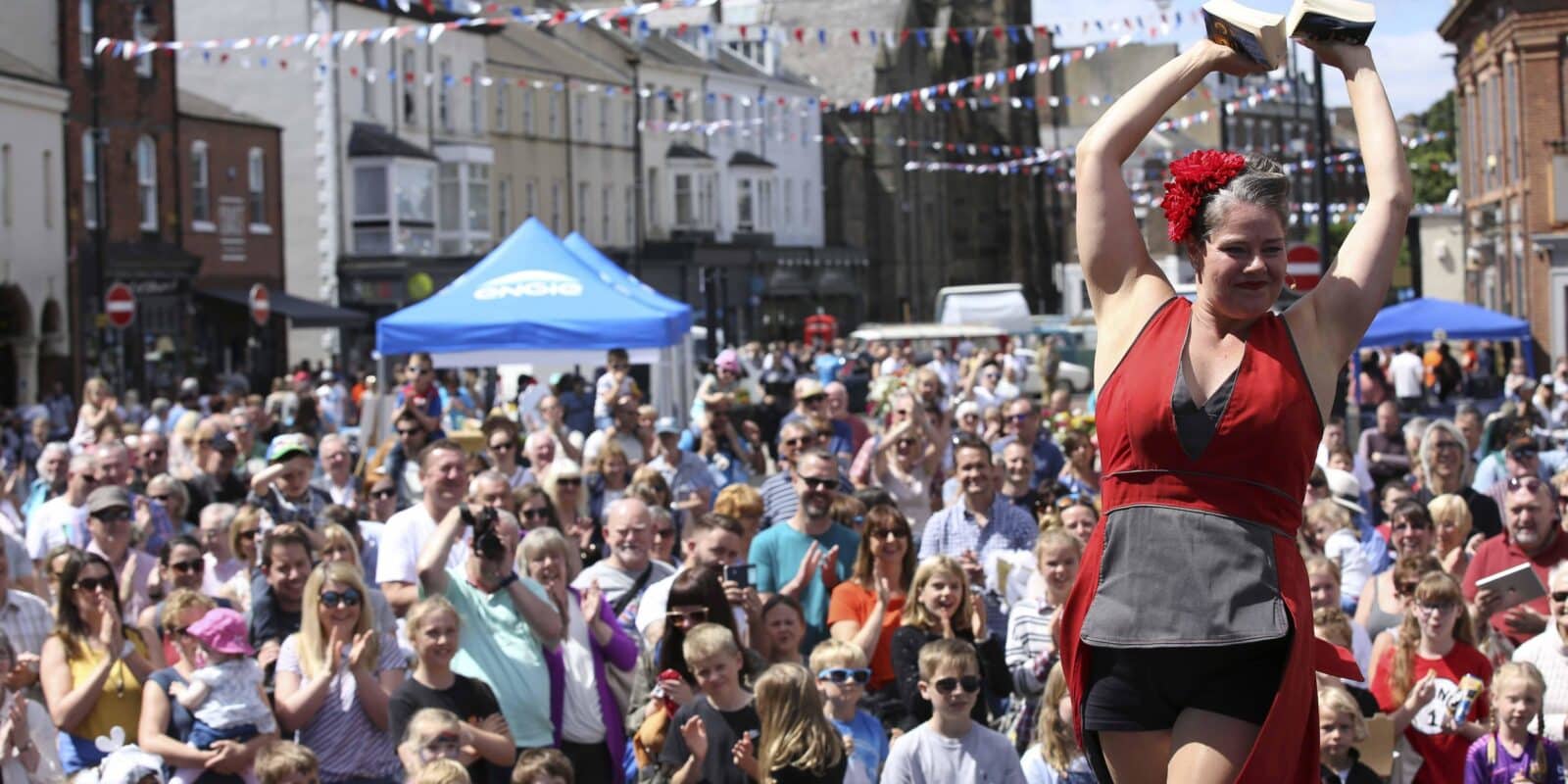 Woman in red performing in front of a large crowd in Great Yarmouth