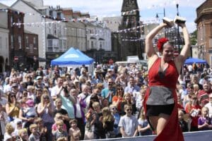 Woman in red performing in front of a large crowd in Great Yarmouth