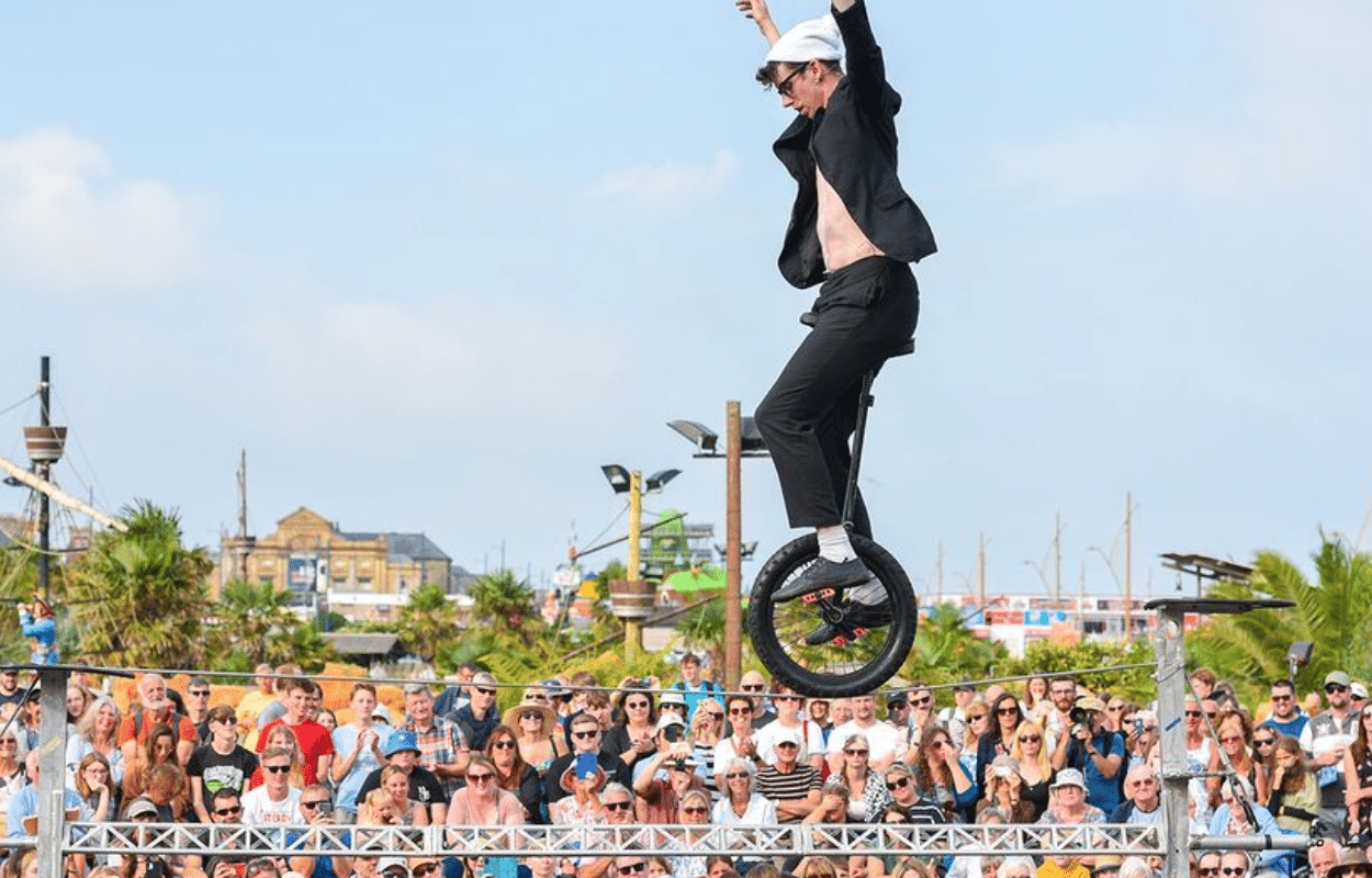 Man on unicycle in front of a massive audience