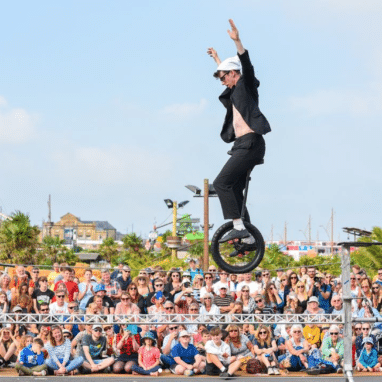 Man on unicycle in front of a massive audience