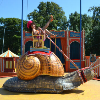 A performer on top of a giant snail