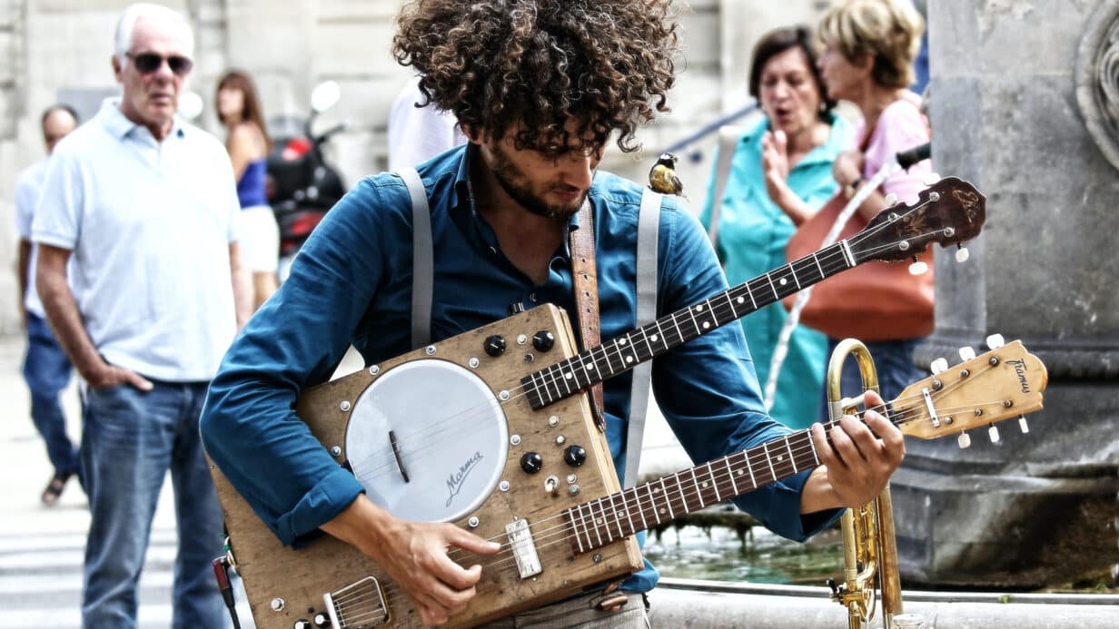 A person playing a Guitanjo in the street