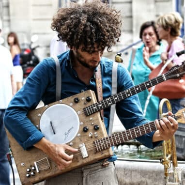 A person playing a Guitanjo in the street