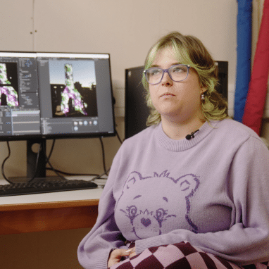 Person with green hair sat in front of computer