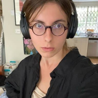 Selfie of lady with round glasses wearing headphones