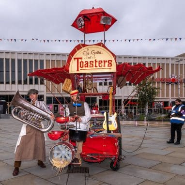 Band dressed as cooks with instruments and contraptions