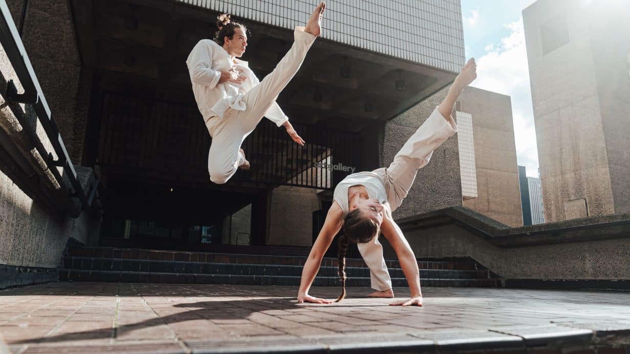 Two dancers gracefully jumping through the air