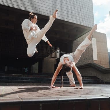 Two dancers gracefully jumping through the air