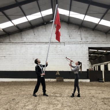 Two people holding a red flag