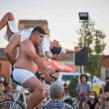 Man cycling with lady over his shoulder