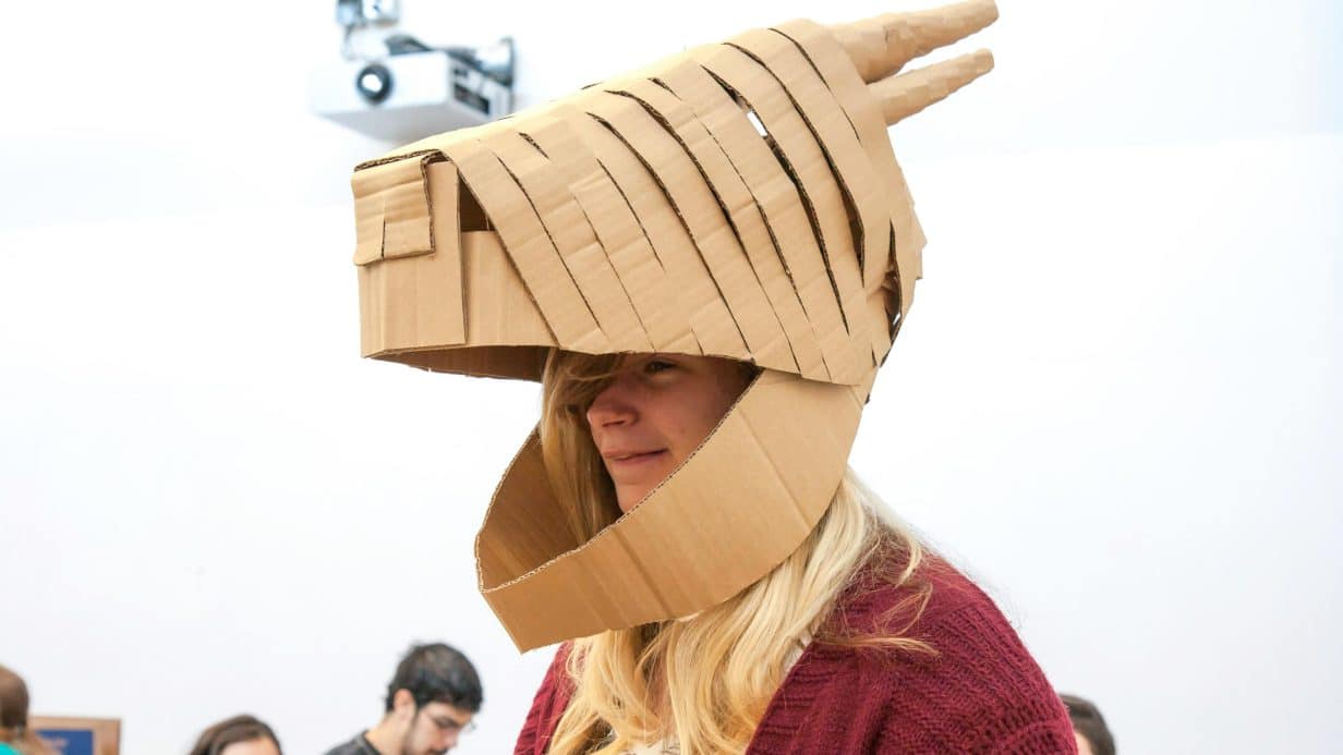 Girl wearing cardboard animal mask