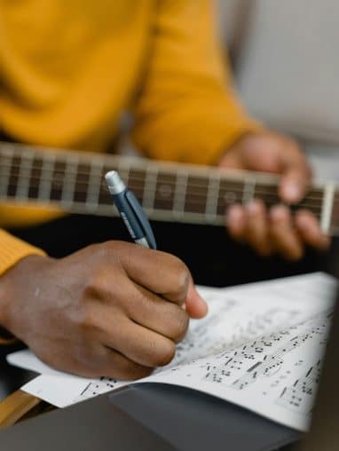 pexels-tima-miroshnichenko-6670789 Person writing a song playing guitar