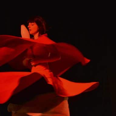 Lady spinning with skirts and juggling clubs