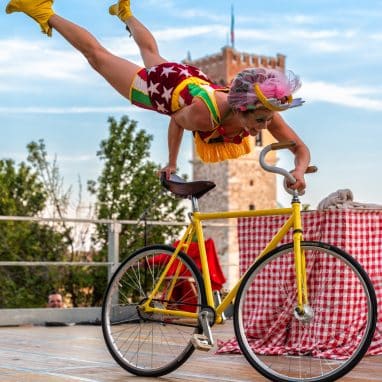 Lady doing a handstand on a bike