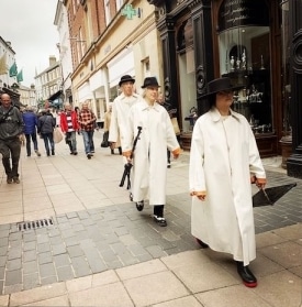 3 people in a line all wearing white