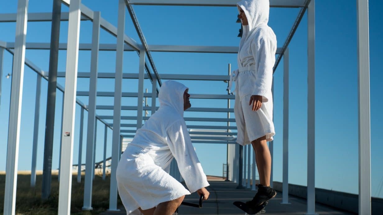 People dressed in robes balancing on a bicycle