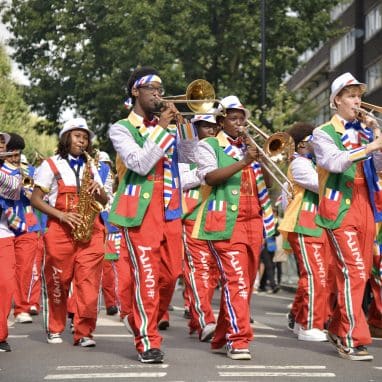 Band playing instruments wearing bright colours