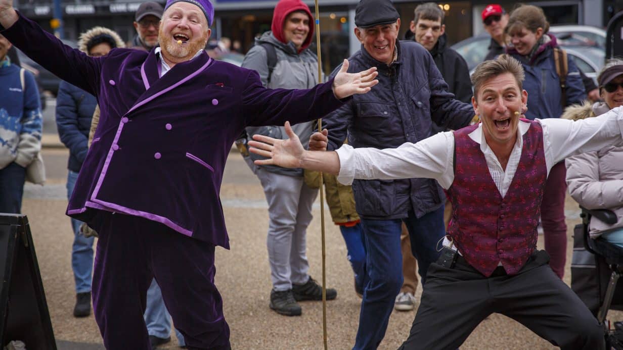 Two men with their arms out cheering