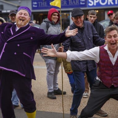 Two men with their arms out cheering