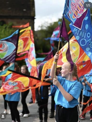 Beach of Dream – Flag Parade 1 Girl holding brightly coloured flag