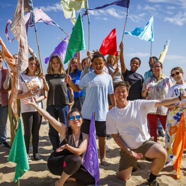 Group of young people smiling and holding flags