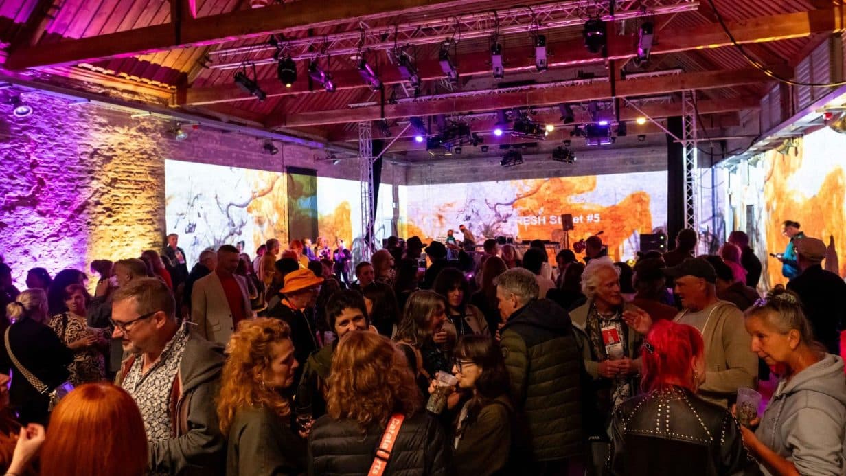 Shot of inside The Ice House. Lots of people surrounded by immersive and creative projections