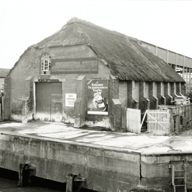Black and white photo of ice house with thatched roof