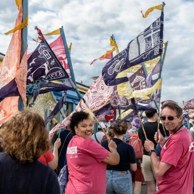 Volunteers holding colourful flags